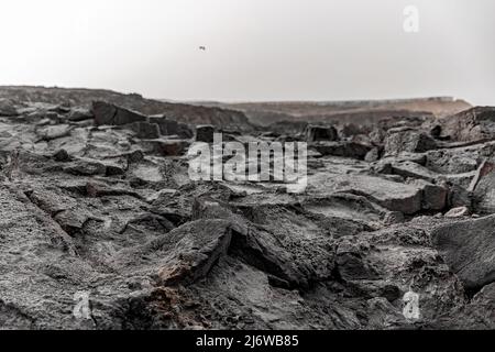 Schwarze Felsstruktur. Nahaufnahme der vulkanischen Bergoberfläche Stockfoto