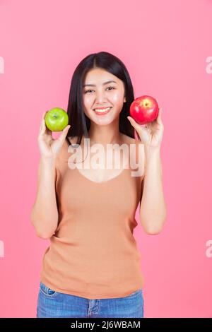 asiatische Frau glücklich hält grünen Apfel und roten Apfel. Stockfoto
