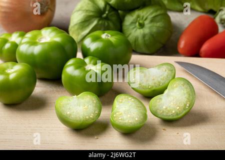 Frisch grün ganz und halbierte Tomatillo auf einem Schneidebrett aus der Nähe Stockfoto