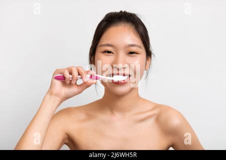 Portrait of young Asian woman brushing her teeth Stockfoto