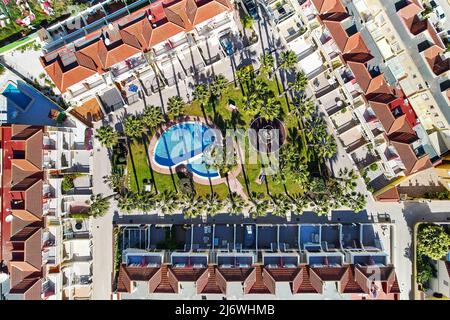 Luftaufnahme von oben Moderne Urbanisierung Dächer mit gepflegten Garten im Innenhof, Palmen und Schwimmbad, keine Menschen. Sommerurlaub Stockfoto