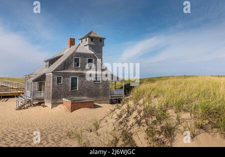 Blauer Himmel und Dünen mit Gras vor dem Gebäude der lebensrettenden Station in Provincetown Stockfoto