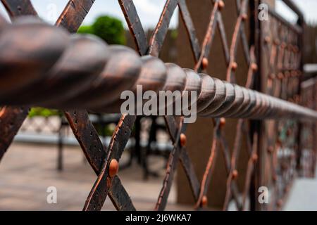 Schmiedeeiserne und verdrehte Geländer. Metallprodukte. Stilisierung des Designs im alten Stil Stockfoto