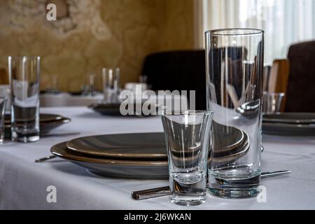 Tabelleneinstellung. Besteck. Glas, Stapel, Schüsseln und Gabel auf dem Tisch. Stockfoto