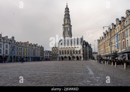 Arras, Frankreich - 4. November 2021: Marktplatz von Arras, Frankreich. Der Belfried von Arras, das zum UNESCO-Weltkulturerbe gehört, steht vor einem dunkelgrauen Himmel Stockfoto