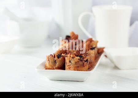 Kleine Kuchen mit Mandeln, Rosinen und Honig auf einem weißen Tisch. Stockfoto