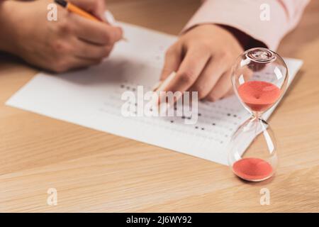 Zugeteilte Zeit für Prüfung und Schüler Handprüfung in der Übung und bestandener Prüfung Kohlepapier Computerblatt mit Bleistift in der Schule Testraum, Bildung Co Stockfoto