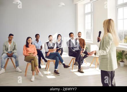 Lady Business Coach führt eine Präsentation, schult ein Team für eine multirassische Gruppe junger Menschen Stockfoto