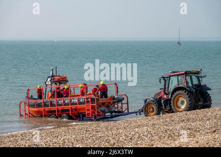 Rettungsboot wird mit einem Traktor in der Stokes Bay Hampshire England ins Meer gestartet Stockfoto