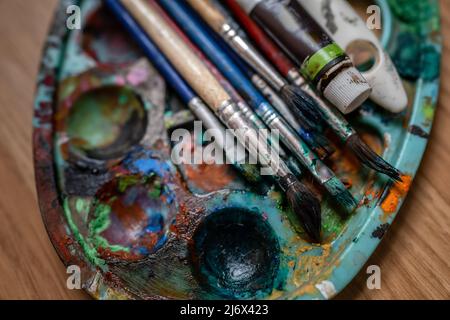 Nahaufnahme von oben auf Pinsel und Malerfarbpalette Kunstkonzept Stockfoto
