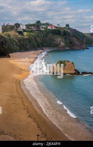 Tenby North Beach, Blick auf North Beach in Tenby mit seiner unverwechselbaren Felsformation - Goskar Rock - am Strand, Pembrokeshire. Stockfoto