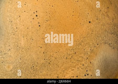 Hintergrund mit Kaffeestextur. Starker Espresso extrem dunkler Kaffee brauner Schaum in Nahaufnahme Stockfoto