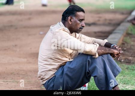 Vellore, Tamil Nadu, Indien - 2018. September: Ein Inder, der allein unglücklich in einem Park sitzt, mit einem traurigen, besorgten, angespannten Gesichtsausdruck. Stockfoto
