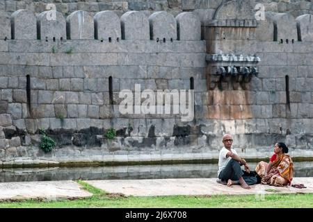 Vellore, Tamil Nadu, Indien - 2018. September: Ein älterer indischer Mann und eine ältere Frau sitzen in einem Park vor dem alten Fort von Vellore. Stockfoto