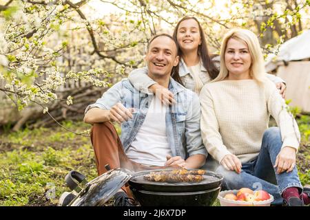 Glückliche Familie mit Grill mit modernen Grill im Freien Stockfoto