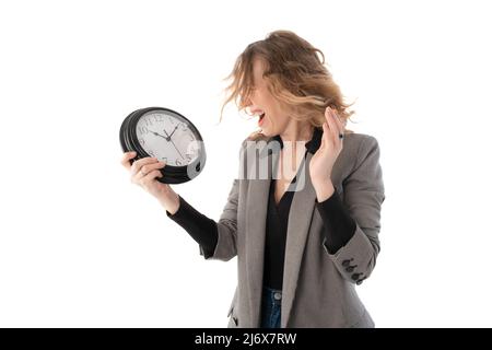 Lächelnde Frau, die eine große Uhr in den Händen hält. Zeit zum Ausruhen, Entspannen, Urlaubskonzept. Isoliert auf Weiß Stockfoto