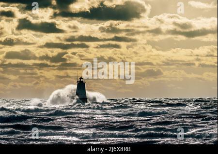 Große Welle stürzt über den Leuchtturm am Nordwall im Streans Park in Ludington, Michigan, USA. Stockfoto