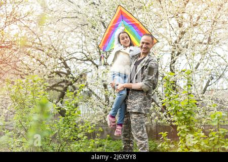 Schöner Soldat an einem sonnigen Tag wieder mit der Familie vereint. Stockfoto