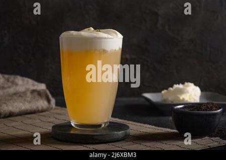 Chinesischer Käsetee mit Schlagsahne, schwarzer Tee auf schwarzem Hintergrund. Speicherplatz kopieren. Nahaufnahme. Stockfoto