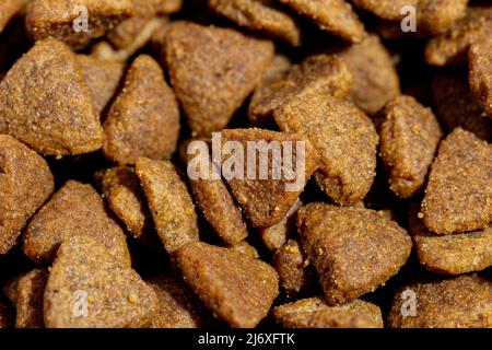 Hunde- oder Katzenfutter oder Kibble sind aus der Nähe geschossen. Draufsicht Hintergrund Stockfoto