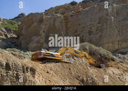 Yellow Raupenbagger arbeitet an der Reparatur einer Straße in den Bergen Stockfoto