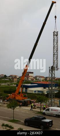 Zweiter Abschnitt des Mastes eines Turmdrehkrans, der von einem LKW-Kran auf einer Baustelle in Santander Cantabria Spanien in Position gehoben wird Stockfoto