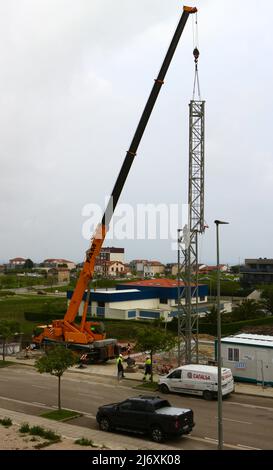 Zweiter Abschnitt des Mastes eines Turmdrehkrans, der von einem LKW-Kran auf einer Baustelle in Santander Cantabria Spanien in Position gehoben wird Stockfoto