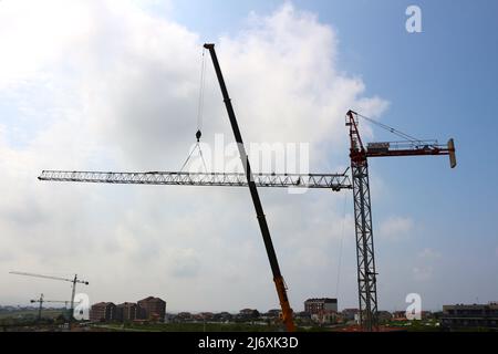 Horizontaler Ausleger eines Turmdrehkrans, der von einem LKW-montierten Mobilkran Santander Cantabria Spanien in Position gehoben wird Stockfoto