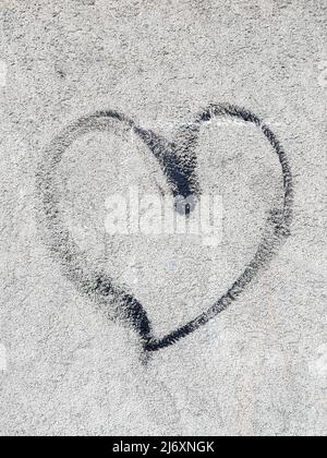 Konzept oder konzeptuelle schwarz lackiert abstrakte Herzform Liebe Symbol, schmutzige Wand Hintergrund, Metapher für die städtischen und romantischen Valentine, Grunge Stil. Stockfoto