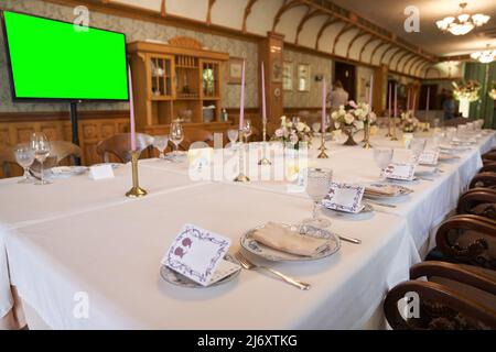 Luxuriöse Tischkulisse für einen Urlaub auf grünem TV-Hintergrund. Leere Weingläser im Restaurant. Teil des Innenraums. Hochwertige Fotos Stockfoto