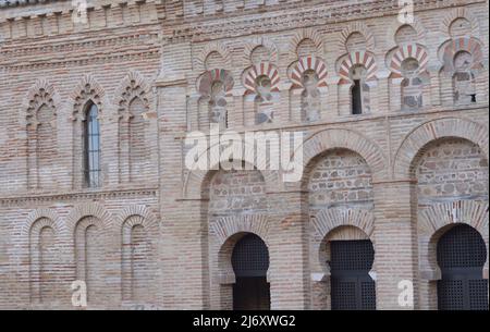 Toledo, Kastilien-La Mancha, Spanien. Schrein von Cristo de la Luz. Ehemalige Moschee, Ende des 10.. Jahrhunderts erbaut und im 12.. Jahrhundert in eine christliche Kirche umgewandelt. Architektonisches Detail der Nordwestfassade. Es ist aus Backstein gebaut und verfügt über drei halbrunde Bögen, die von Hufeisenbögen umrahmt sind, mit Öffnungen, die zum Gebetsraum führen. Der obere Teil besteht aus polygelappten Bögen, die Hufeisenbögen im Stil des Khiphals umrahmt und mit Voussoirs verziert sind. Stockfoto