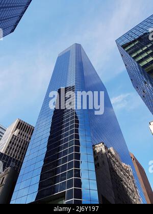 Verspiegelter Wolkenkratzer im Stadtzentrum von unten. Das Hochhaus aus Glas spiegelt den Himmel und die Straßen wider Stockfoto