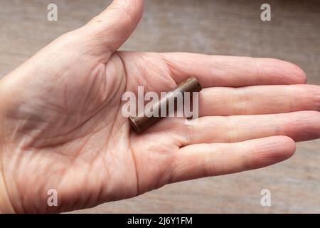 Eine Patronenhülle aus einer alten Naganrevolver-Patrone in Ihrer Handfläche. Kriegsfunde des frühen 20.. Jahrhunderts. Stockfoto