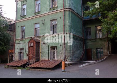 Altes historisches Gebäude, grünes Haus und alte braune Türen und Fenster auf einer ruhigen Straße in Kiew, Ukraine Stockfoto