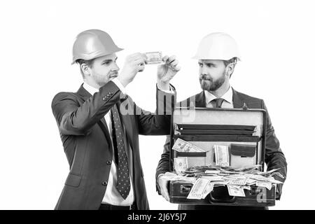 Finanzielle Unterstützung. Investition in Architekturprojekt. Zwei Männer Geschäftsmann in Hardhat mit Geld. Stockfoto