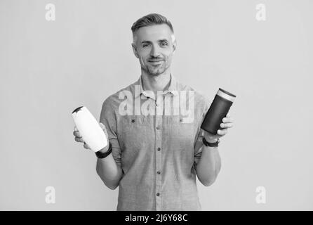 Guy wählen Shampoo-Flasche oder Haarspülung. Tägliche Gewohnheiten und persönliche Pflege. Stockfoto