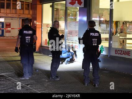 04. Mai 2022, Nordrhein-Westfalen, Duisburg: Polizeibeamte suchen nachts auf dem Hamborn Altmarkt in Marxloh nach Spuren der Schüsse. Bei einer Auseinandersetzung mit Schusswaffen in Duisburg sind am Mittwochabend vier Personen verletzt worden. Foto: Roberto Pfeil/dpa Stockfoto