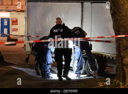 04. Mai 2022, Nordrhein-Westfalen, Duisburg: Polizeibeamte suchen nachts auf dem Hamborn Altmarkt in Marxloh nach Spuren der Schüsse. Bei einer Auseinandersetzung mit Schusswaffen in Duisburg sind am Mittwochabend vier Personen verletzt worden. Foto: Roberto Pfeil/dpa Stockfoto