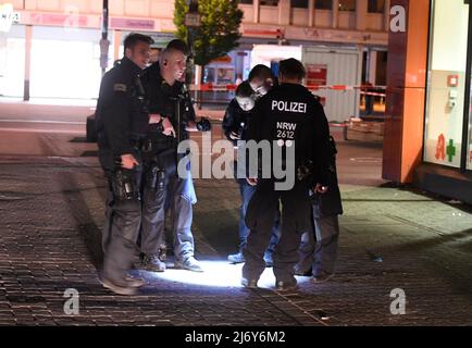 04. Mai 2022, Nordrhein-Westfalen, Duisburg: Polizeibeamte suchen nachts auf dem Hamborn Altmarkt in Marxloh nach Spuren der Schüsse. Bei einer Auseinandersetzung mit Schusswaffen in Duisburg sind am Mittwochabend vier Personen verletzt worden. Foto: Roberto Pfeil/dpa Stockfoto