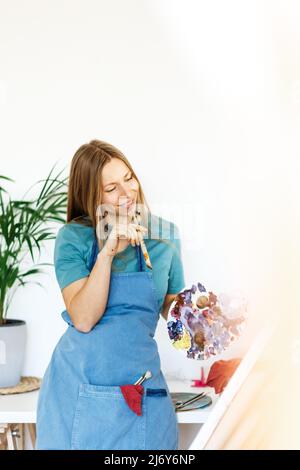 Frau bereitet leckere grüne Smoothie in der Küche Stockfoto