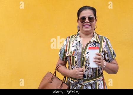 Hispanische Frau, die mit einem Kaffee zum Mitnehmen arbeitet Stockfoto