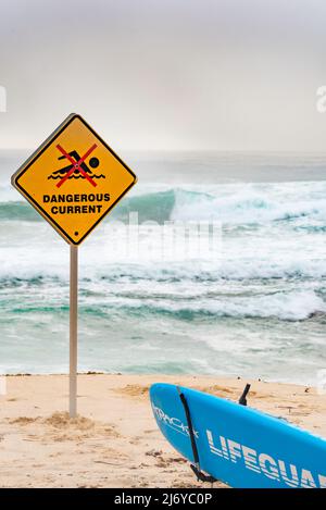 März 2022:Ein gefährliches Stromschild am Bronte Beach in Sydney, Australien an einem Wochenende voller wilder Brandung und Nebel am frühen Morgen, die einen grauen Hintergrund erzeugen Stockfoto