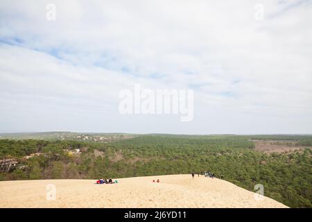 Bild von Menschen, die an einem sonnigen Nachmittag die Pyla Sand Düne erklimmen. Die Düne von Pilat (Dune du Pilat auf Französisch, oder Pyla) ist der höchste Sanddun Stockfoto