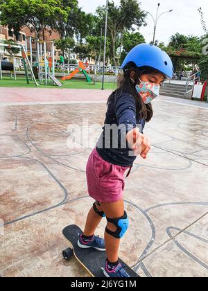 Schöne Skater Mädchen Reiten auf ihrem Longboard in der Stadt Stockfoto