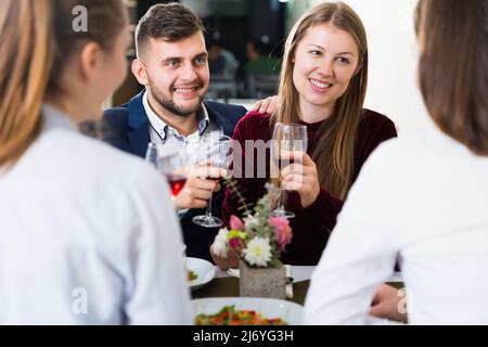 Gentleman mit eleganten Frauen essen im luxuriösen Restaurant zu Abend Stockfoto