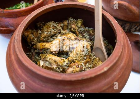 Peruanische Küche: Huhn und Reis genannt Arroz con pollo in einem Tontopf Stockfoto