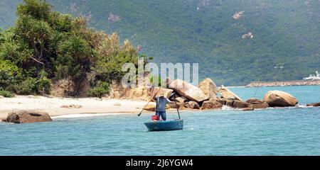 Ein Einheimischer rudert sein kleines Boot in der Nähe des Nordufers der Peng Chau Insel, Hongkong. Stockfoto