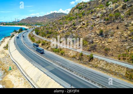 Die Küstenstraße in der Bucht Ca Na, Binh Thuan von oben mit dem Boulevard und der Eisenbahn gesehen, gilt die Küste nahe beieinander als eine schöne Bucht Stockfoto