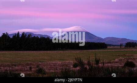 Wolken treiben über Mt Ngauruhoe bei Sonnenuntergang, North Island. Stockfoto