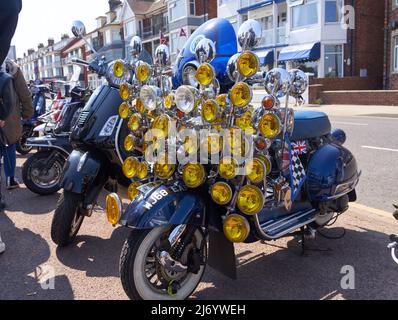 Klassischer Motorroller mit vielen Lampen an der Front in Skegness, Lincolnshire, UK Stockfoto